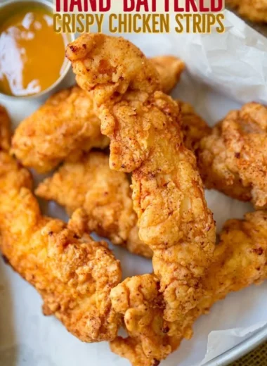 Golden crispy chicken tenders served with dipping sauce on a plate