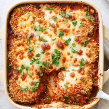 Delicious Baked Eggplant Parmesan topped with melted cheese and herbs.