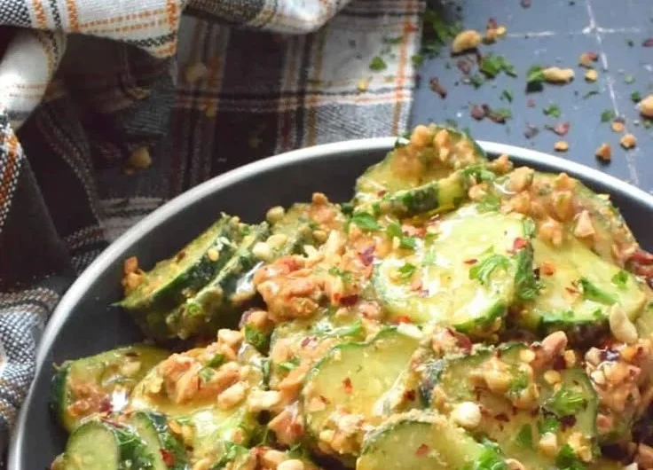 Cucumber Salad drizzled with Peanut Sauce served in a bowl