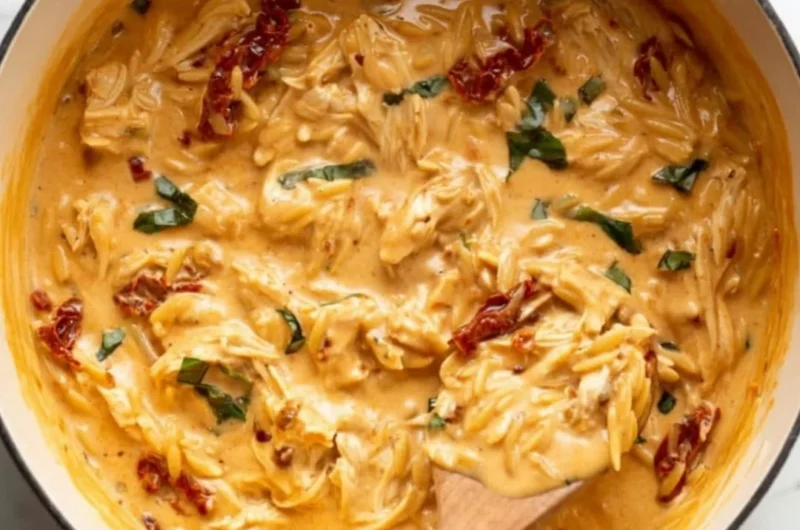 Marry Me Chicken Orzo served on a plate with fresh herbs and ingredients.