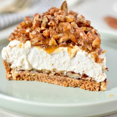 No-Bake Keto Pecan Pie Cheesecake topped with pecans and caramel sauce