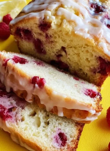 Freshly baked Raspberry Lemon Loaf with vibrant raspberries and lemon glaze.