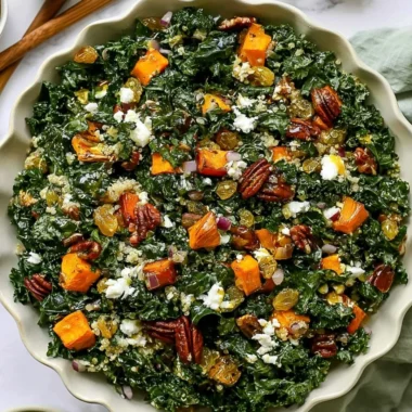 Roasted sweet potato kale salad bowl topped with fresh greens and nuts