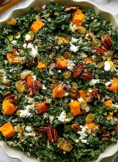 Roasted sweet potato kale salad bowl topped with fresh greens and nuts
