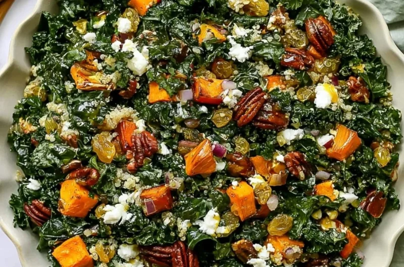 Roasted sweet potato kale salad bowl topped with fresh greens and nuts