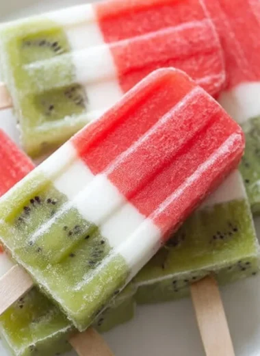 Homemade watermelon popsicles on a sunny outdoor table.