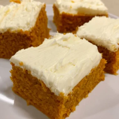 Delicious cozy pumpkin cream cheese bars topped with a creamy swirl.