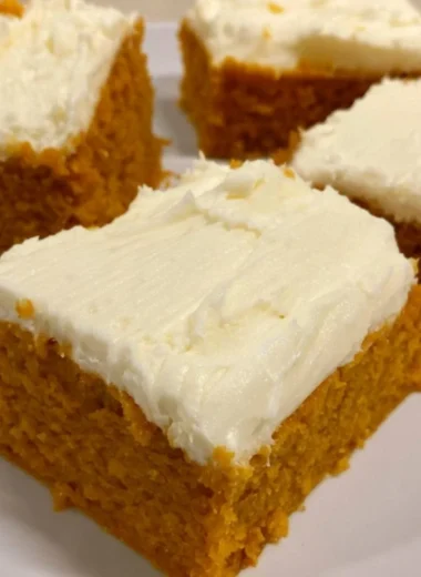 Delicious cozy pumpkin cream cheese bars topped with a creamy swirl.