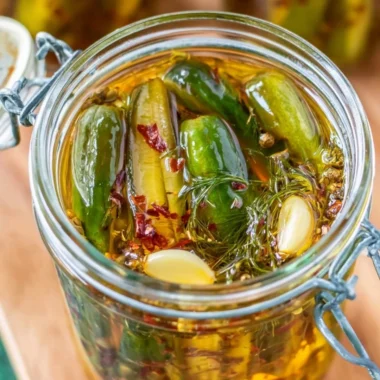Jar of cozy smoked pickles with fresh herbs and spices