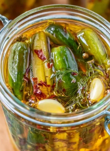 Jar of cozy smoked pickles with fresh herbs and spices