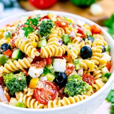 Bowl of vibrant and colorful Italian Pasta Salad with fresh vegetables and dressing.