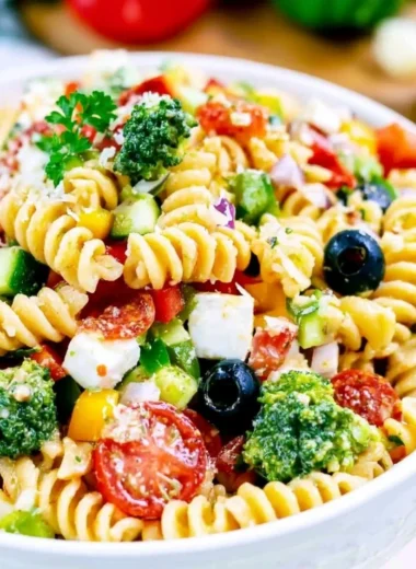 Bowl of vibrant and colorful Italian Pasta Salad with fresh vegetables and dressing.